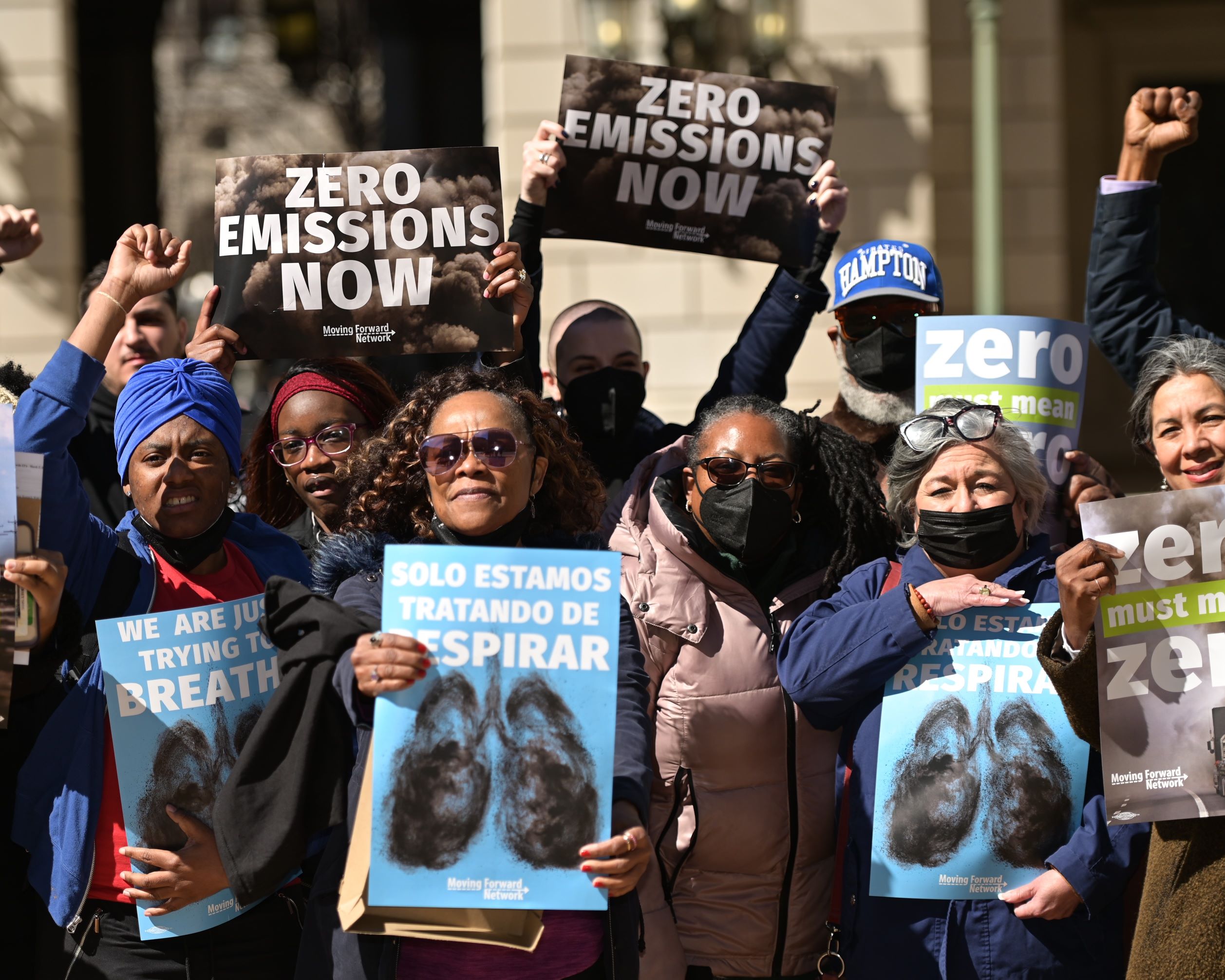 People holding signs that say "Zero Emissions Now"